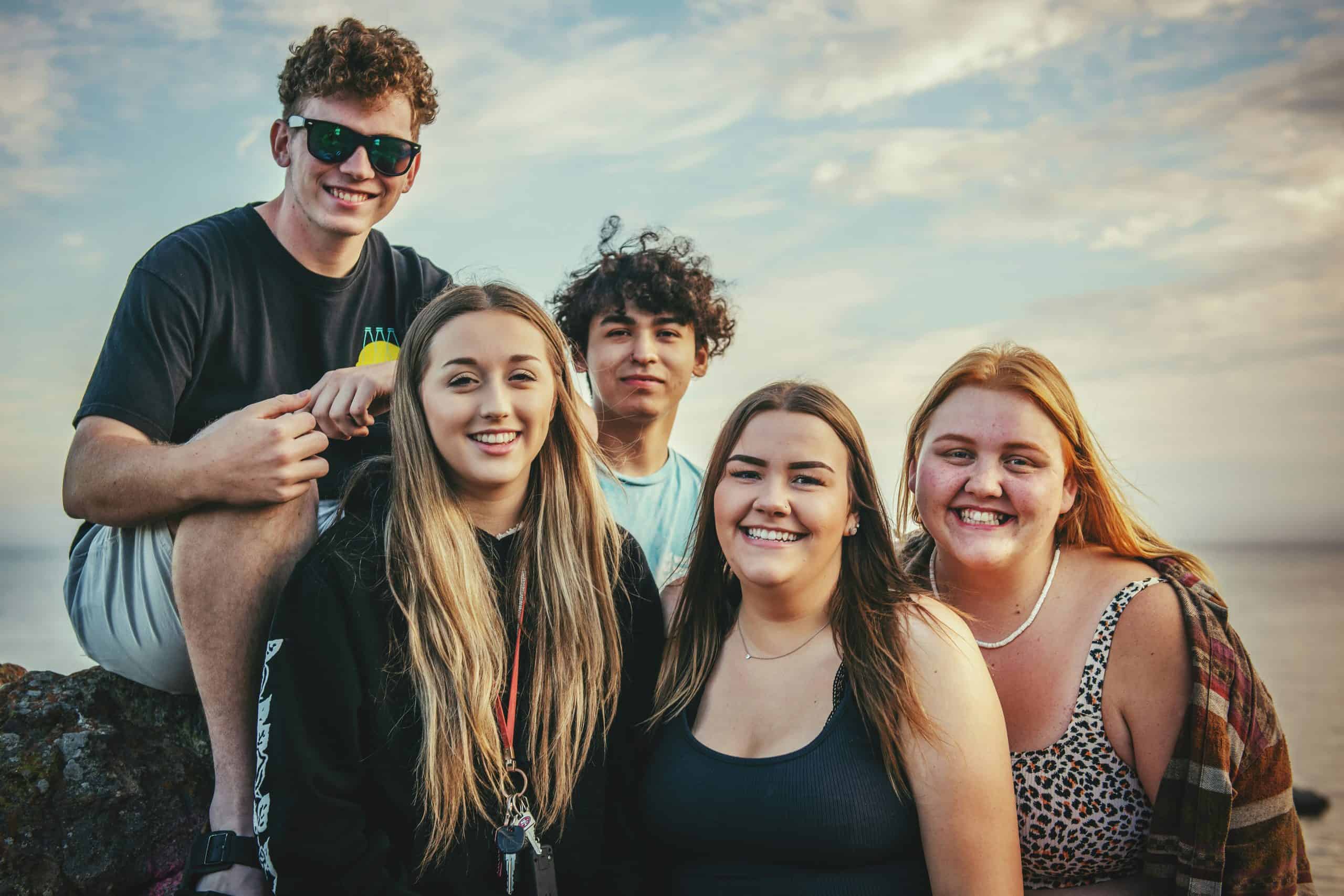 5 Jugendliche die am Meer lachen